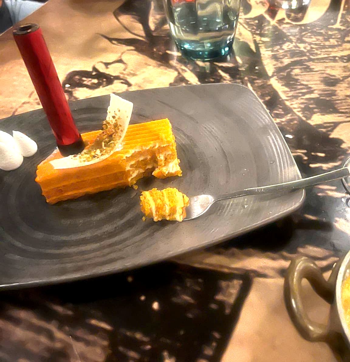 A layered dessert plated with a candle at the resort steakhouse