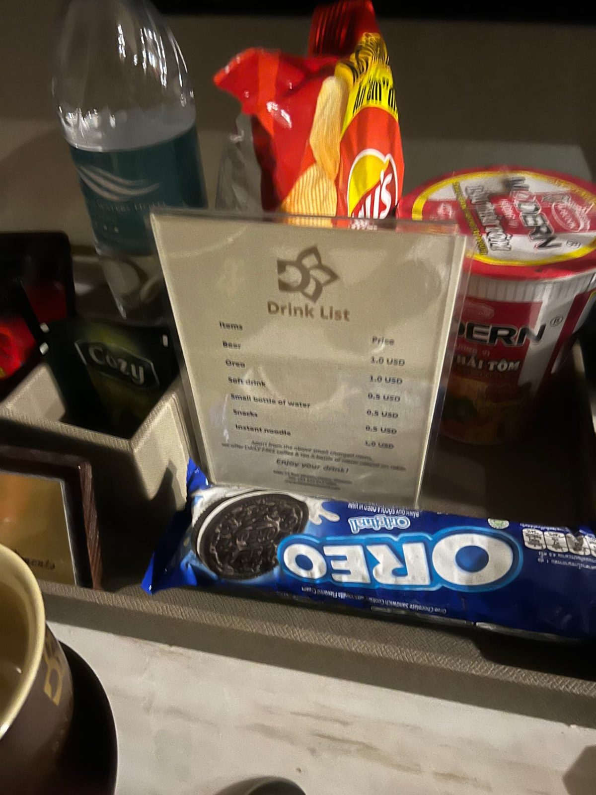 In-room snack tray with drink list, chips, Oreos and instant noodles at the hotel in Hanoi