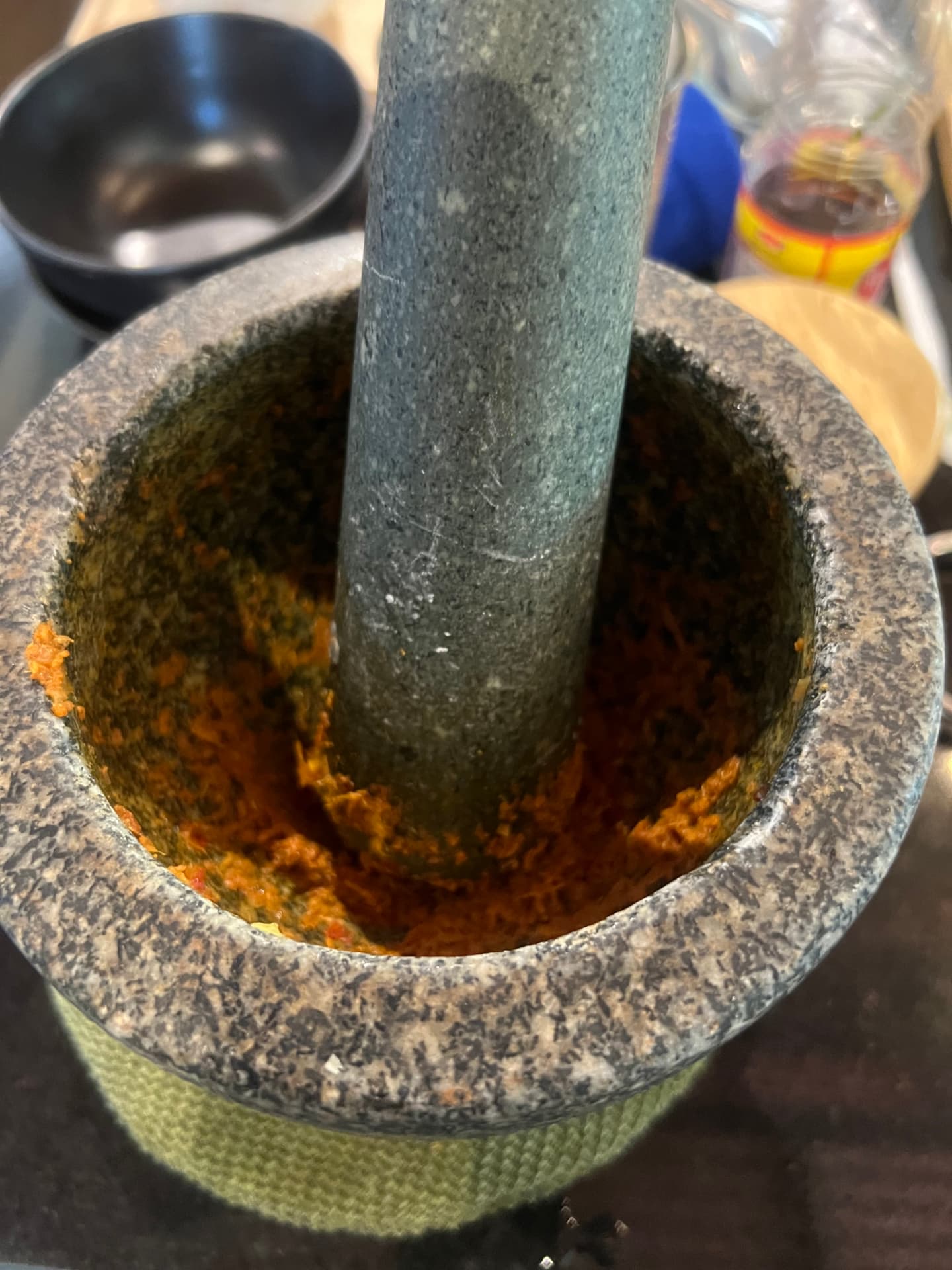 Freshly pounded red Thai curry paste in a granite mortar and pestle
