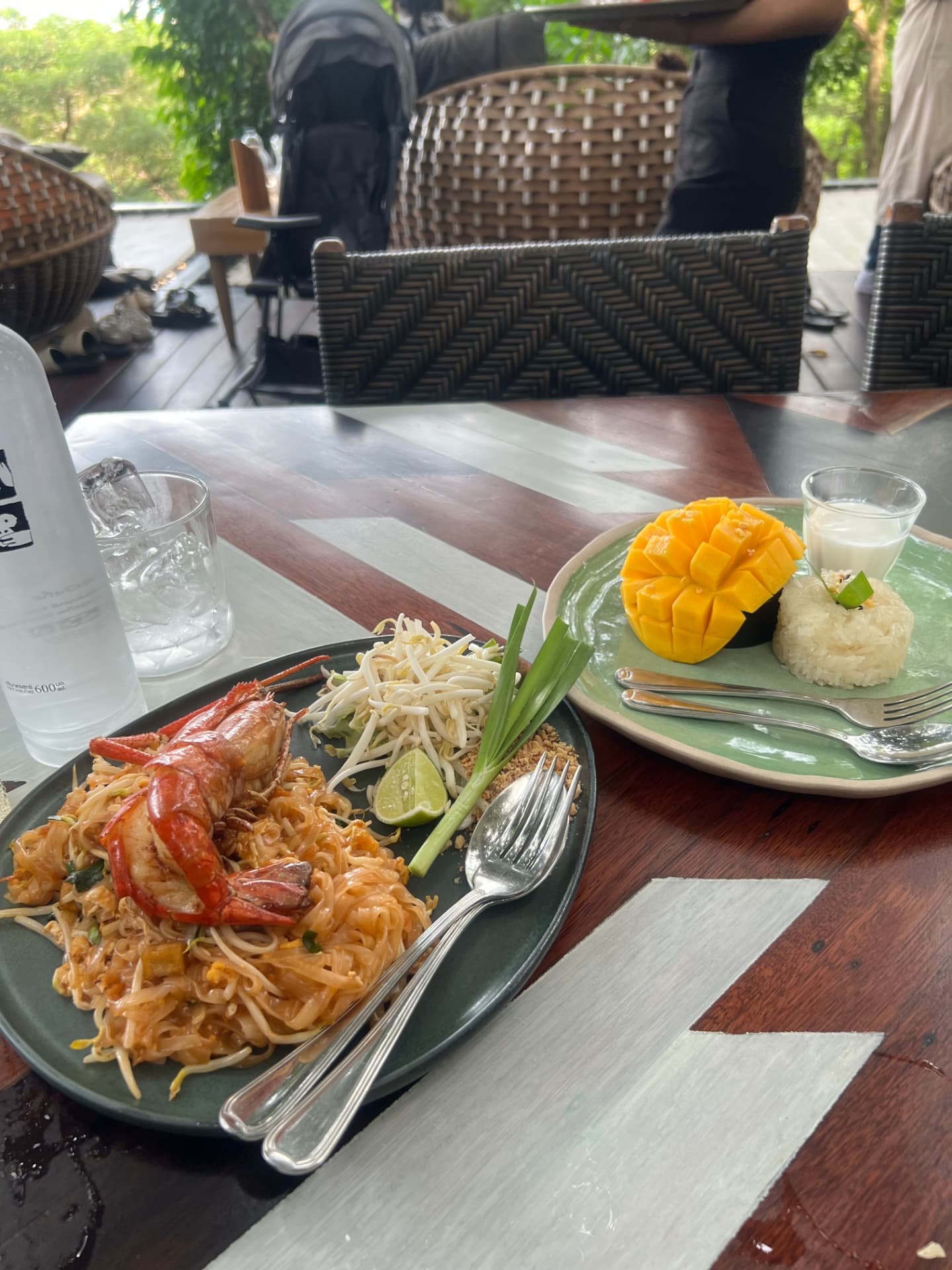 Pad Thai and mango sticky rice on a wooden table in Phuket