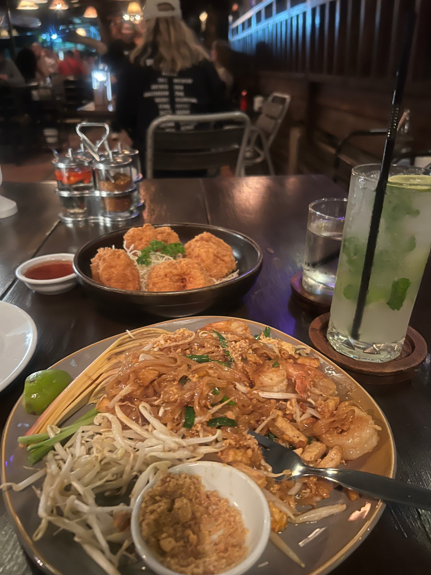 Table at The Good View Restaurant & Bar in Chiang Mai set with Pad Thai and fried appetizers