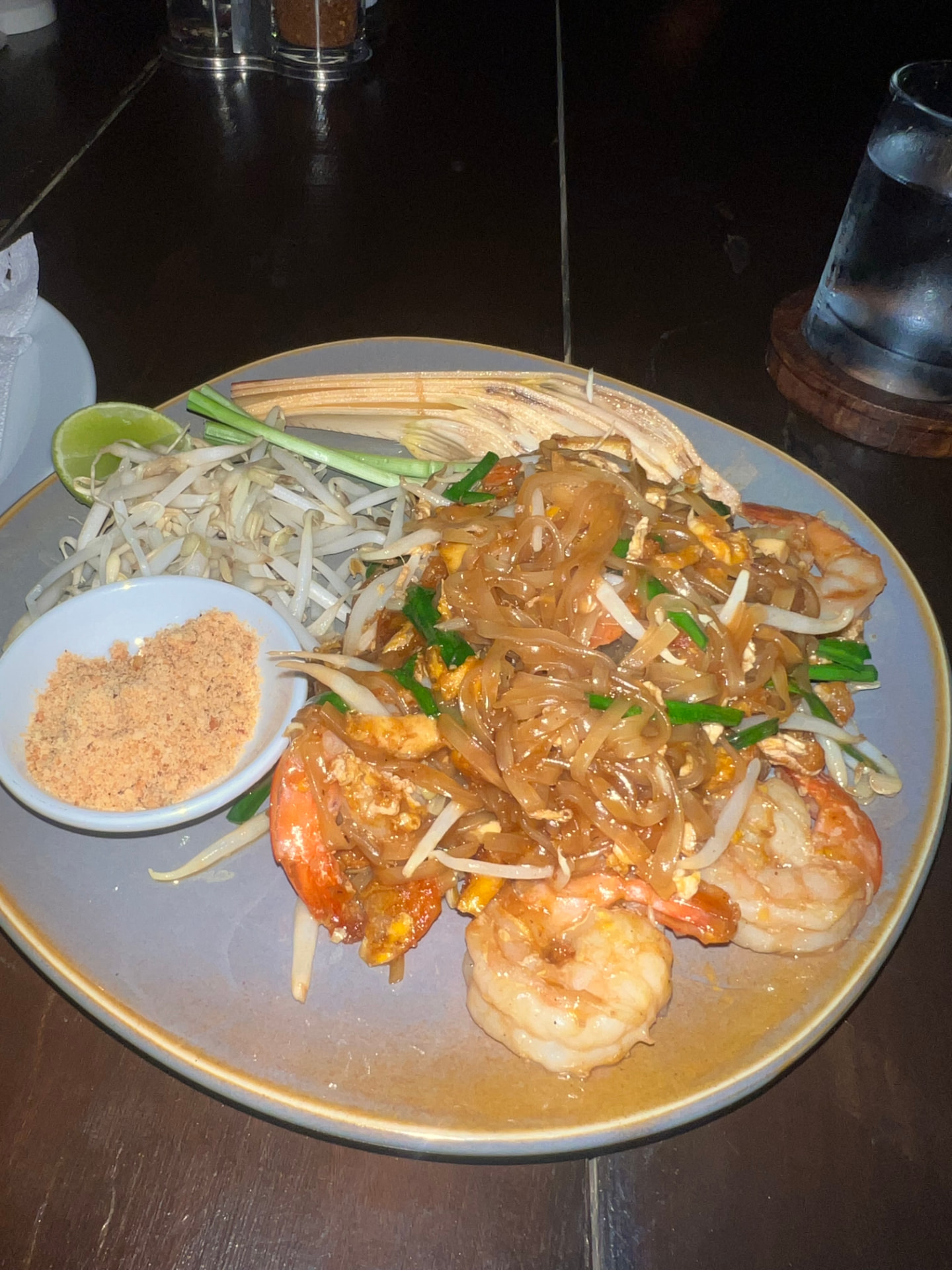 Pad Thai with shrimp, bean sprouts, lime and crushed peanuts on a grey plate at The Good View Restaurant & Bar in Chiang Mai