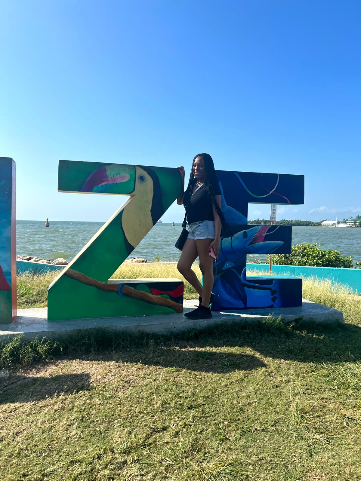 Me posing with the colourful painted BELIZE letters by the water in Belize City