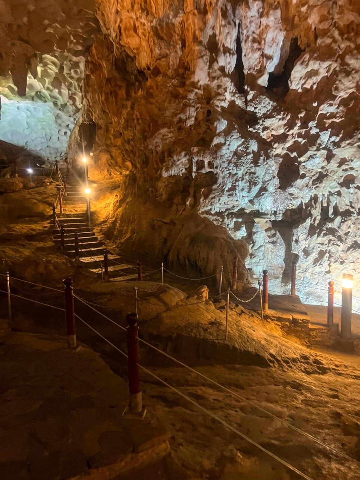 Visitors walking the lit pathway through Sung Sot Cave