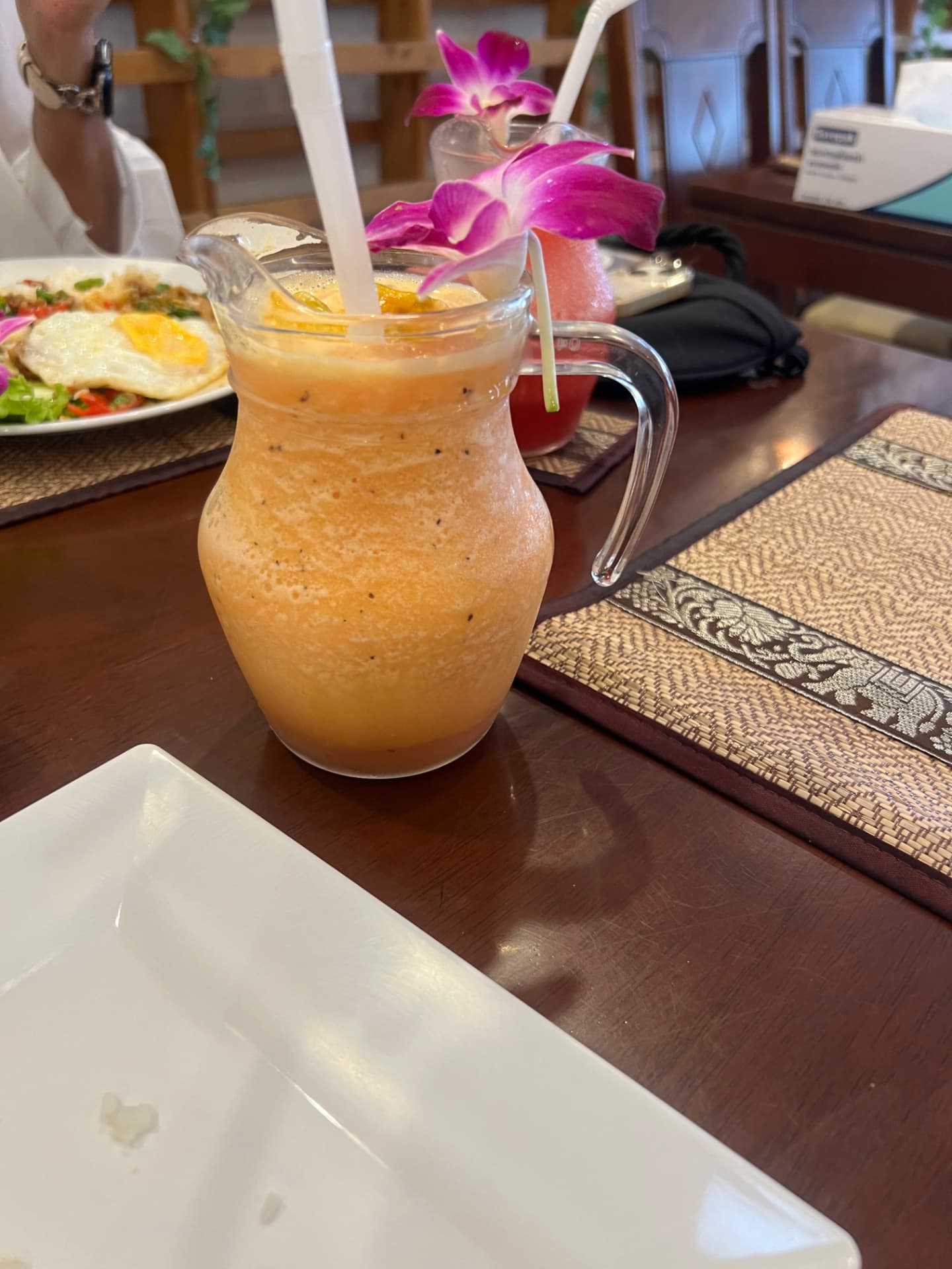 A fresh fruit smoothie served in a small pitcher in Phuket