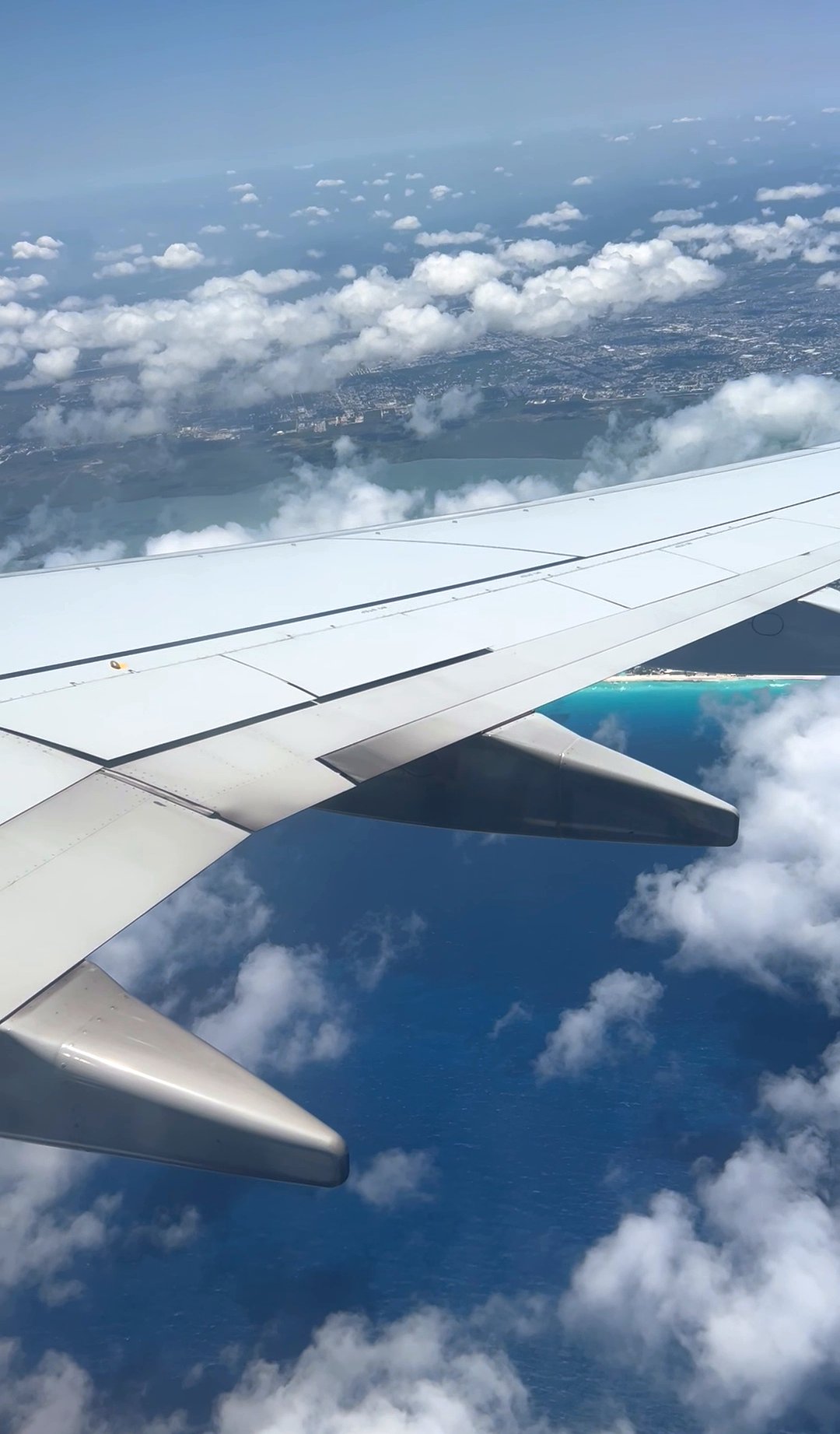 View from the plane window of the turquoise Caribbean coastline on approach into Cancun