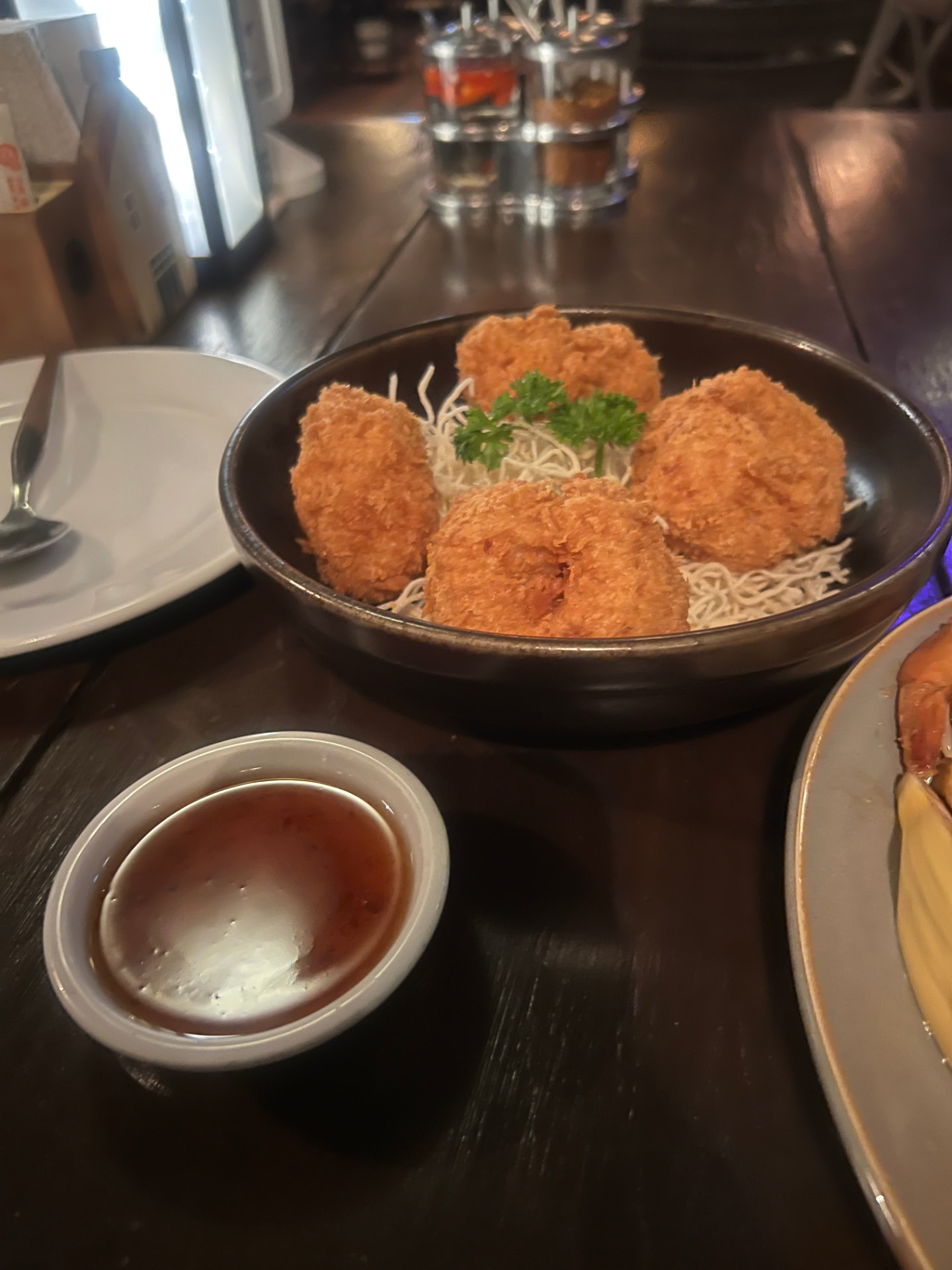 Bowl of crispy golden Thai appetizers with sweet chili dipping sauce at The Good View in Chiang Mai