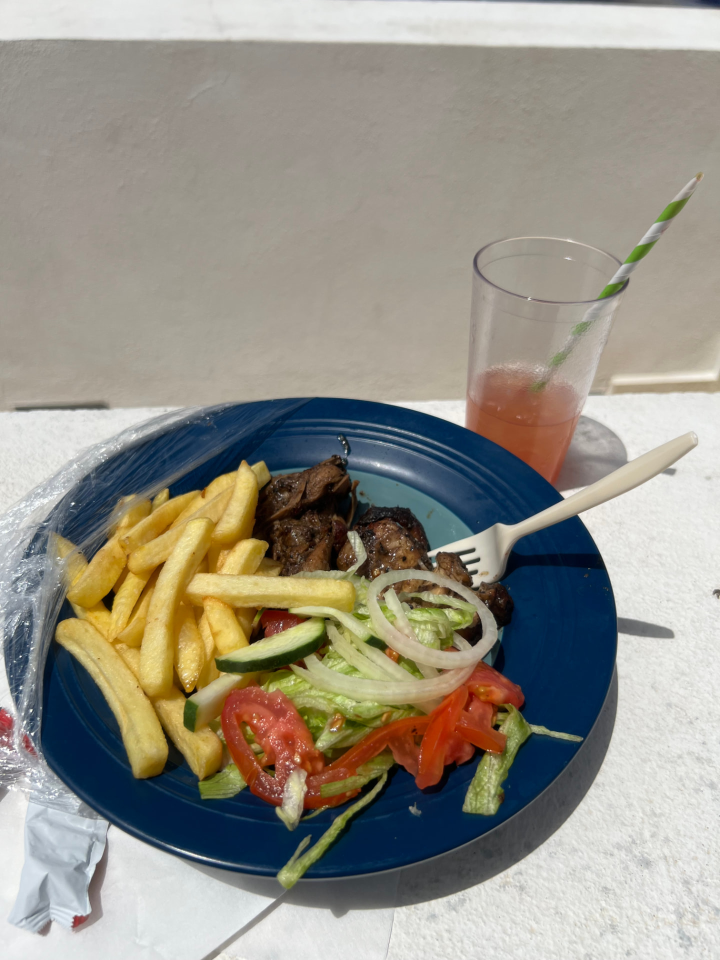 A poolside plate of jerk chicken, fries and salad with a fruit punch at Royalton CHIC Antigua