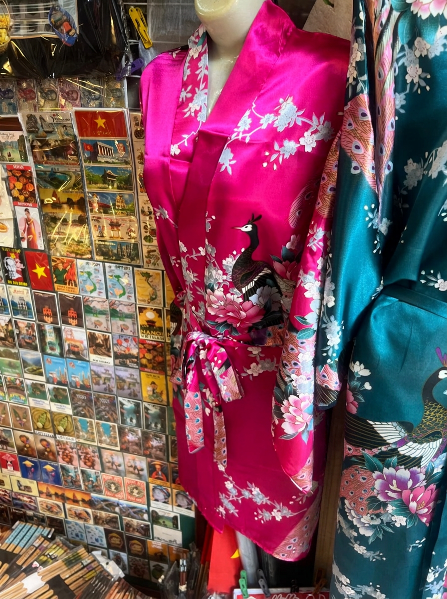 Pink and teal floral Vietnamese silk robes hanging in a shop in Hanoi
